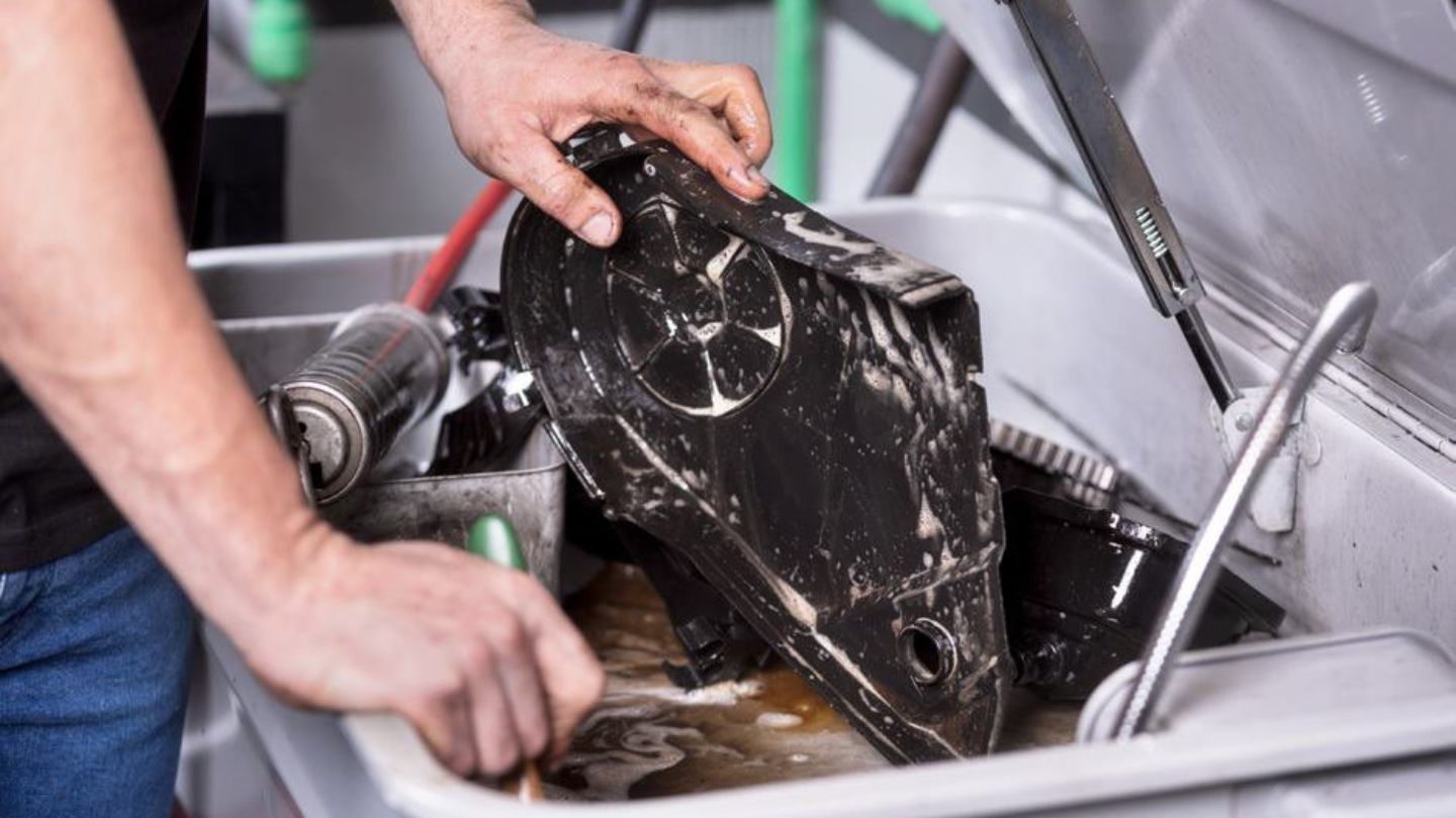 Metal parts being cleaned on a parts washer.