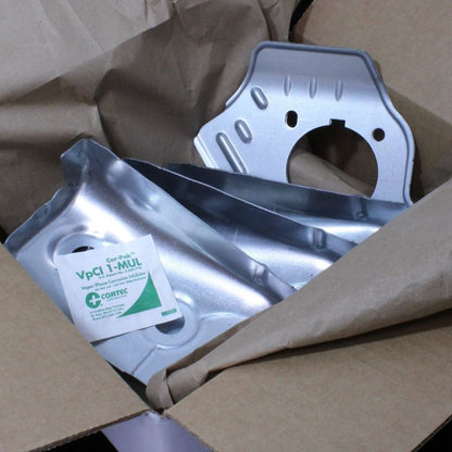 A pouch of Cortec CorPak 1 MUL placed inside a cardboard box containing a metal part.