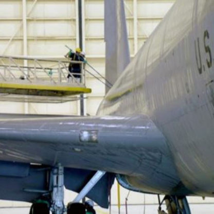 Workers applying VpCI-415 aircraft cleaner to an airplane inside a hangar. 