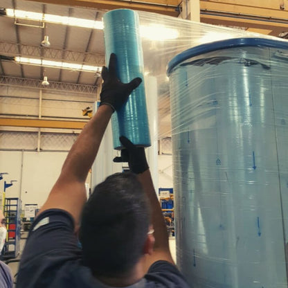 Worker manually wrapping a metal product in Cortec anti rust stretch wrap.